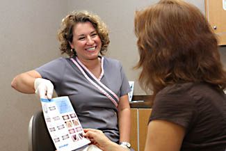 Hygienist showing patient photos of teeth.